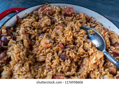 Baking dish with shrimp, sausage, okra, and rice jambalaya and spoon flat lay
