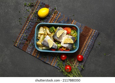 Baking Dish Of Tasty Sea Bass Fish With Vegetables On Black Background