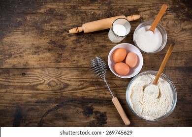 baking ingredients on dark wooden table with empty space