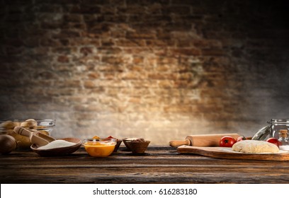 Baking ingredients placed on wooden table, ready for cooking. Copyspace for text. Concept of food preparation, dark background.