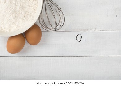 Baking Ingredients Of White Flour And Farm Fresh Brown Eggs With A Whisk On  Distressed Shiplap Wood Board Table With Room Or Space For Copy, Text, Or Your Words.  Horizontal With Looking Down View