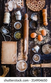 Baking And Pastries Vintage Concept. Various Vintage Kitchen Utensils, Props And Ingredients From Above On A Rustic Dark Wooden Table With Flour, Seeds And Old Book Copy Space. Rustic Dark.
Copy Space