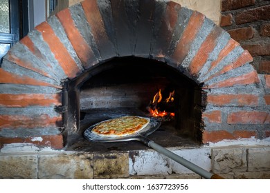 Baking Pizza In Traditional Masonry Oven. Old Wood-fired Brick Oven.