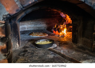 Baking Pizza In Traditional Masonry Oven. Old Wood-fired Brick Oven.