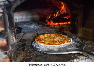 Baking Pizza In Traditional Masonry Oven. Old Wood-fired Brick Oven.