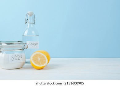 Baking Soda In Jar, Vinegar, Cut Lemon, On A Blue Background. The Concept Of Organic Removing Stains On Clothes. High Quality Photo