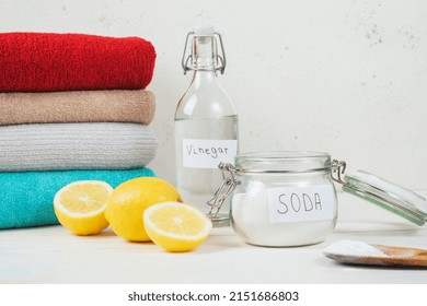 Baking Soda In Jar, Vinegar, Cut Lemon, Folded Towel On A White Background. The Concept Of Organic Removing Stains On Clothes. High Quality Photo