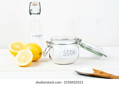 Baking Soda In Jar, Vinegar, Lemon, Wooden Spoon On A White Background. The Concept Of Removing Stains On Clothes. High Quality Photo