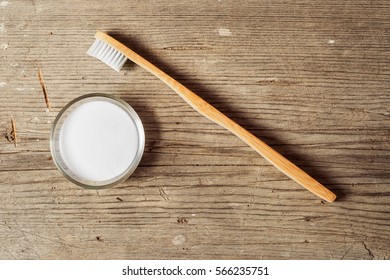 Baking Soda Next To A Tooth Brush On A Wooden Board