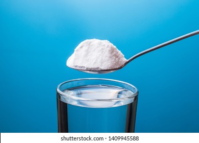 Baking Soda In A Spoon And A Glass Of Water