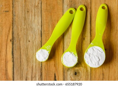 Baking Soda,icing Powder And Baking Powder At Green Measuring Spoon. On Wood Table. Selective Focus