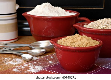 Baking Still Life Of Ceramic Measuring Cups And Stainless Steel Spoons Filled With Ingredients.  Flour Dusted In Foreground.  Macro With Shallow Dof.