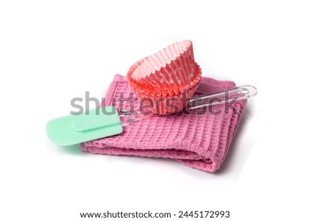 Baking tools on white backgroind. Rubber spatula, kitchen towel and baking cases