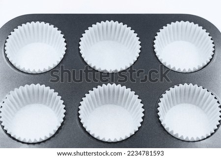 Baking tray with empty muffin paper cases, ready to fill with dough