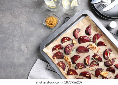 Baking tray with roasted beetroot slices on grey table, flat lay