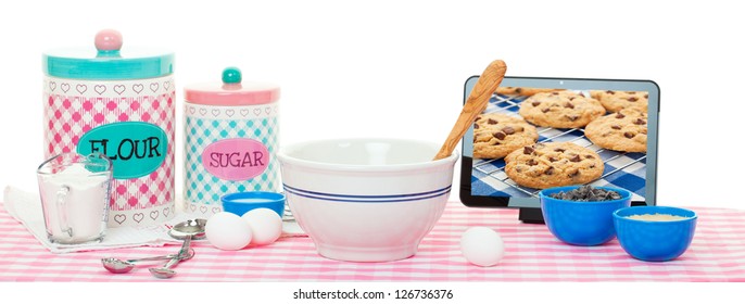 Baking using a tablet with recipe app & the internet.  Chocolate chip image on tablet is also available in my portfolio. - Powered by Shutterstock - Get 15% off with code: PIKWIZARD15