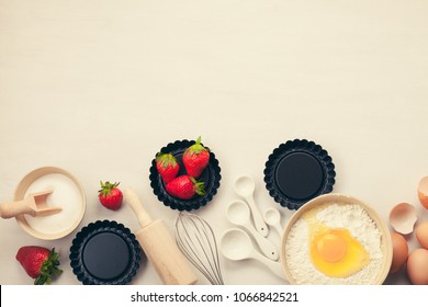 Baking Utensils And Cooking Ingredients For Tarts, Cookies, Dough And Pastry. Flat Lay With Eggs, Flour, Sugar, Berries.Top View, Mockup For Recipe, Culinary Classes, Cooking Blog.