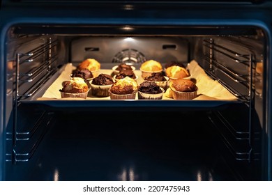 Baking vanilla and chocolate cupcakes in the oven. - Shutterstock ID 2207475943