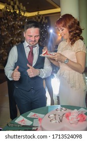 Baku, Azerbaijan .7.04.2019 . Incredible Couple Eating Wedding Cake . Beautiful Bride And Her Husband Eat Cake And They Laugh Together