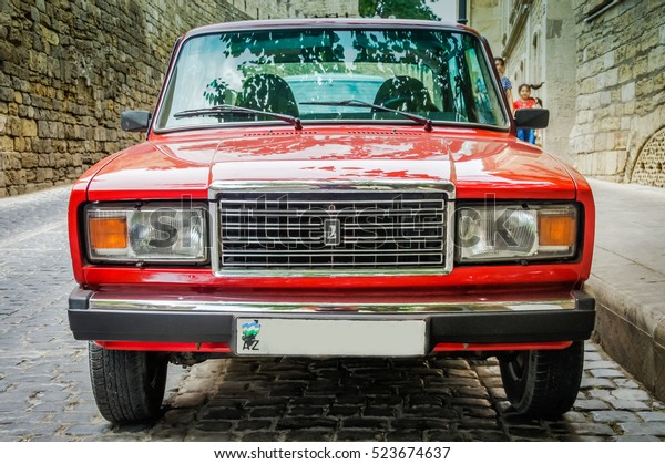 BAKU, AZERBAIJAN - JULY 8, 2016: Old soviet sedan\
car. Front view Lada Auto Vaz. Red classic soviet motor car in the\
city street. Russan vintage car background. Russian classic auto.\
Russian old car