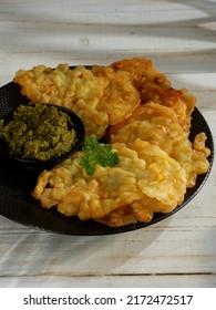 Bakwan Jagung, Corn Fritters With Sambal Hijau (green Chili Sauce) Served On A Black Plate With Pasley Leaf. Indonesian Cuisine, Oily.