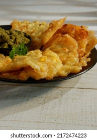 Bakwan Jagung, Corn Fritters With Sambal Merah (red Chili Sauce) Served On A Black Plate With Parsley Leaf. Indonesian Cuisine, Oily.