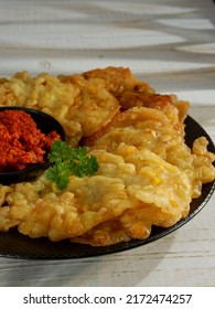 Bakwan Jagung, Corn Fritters With Sambal Merah (red Chili Sauce) Served On A Black Plate With Parsley Leaf. Indonesian Cuisine, Oily.