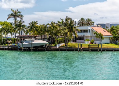 Bal Harbour, USA - May 8, 2018: Wealthy Rich Single Family Home House With Dock And Boat Docked By Waterfront In Miami Florida With Light Green Turquoise Ocean Biscayne Bay Intracoastal Water
