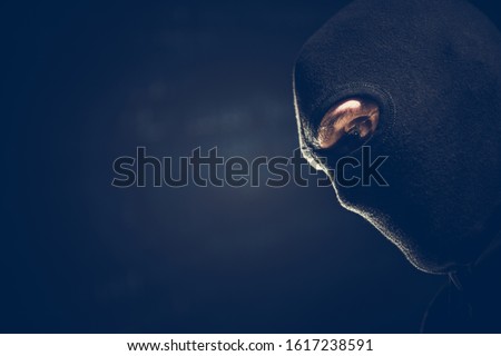 Balaclava Masked Robber Portrait. Caucasian Terrorist or Theft Wearing Black Face Mask. Left Side Copy Space. Dark Theme. Stock photo © 