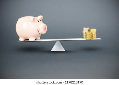 Balance Between Investment And Savings Or Costs With Piggy Bank And Piles Of Cash Money In Balance
