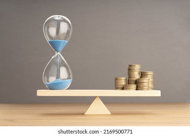 Balance Between Time and money concept. Sand clock and stacked coins on Seesaw. Copy space - Powered by Shutterstock