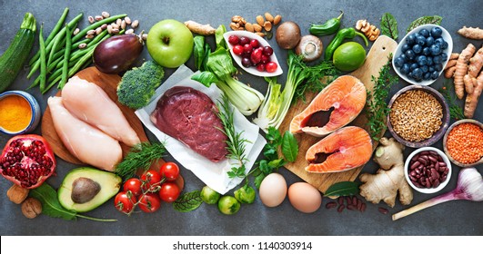 Balanced diet food background. Organic food for healthy nutrition, superfoods, meat, fish, legumes, nuts, seeds and greens 