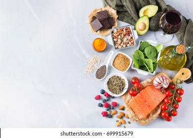 Balanced Diet Food Concept. Assortment Of Healthy Food Low Cholesterol, Spinach Avocado Red Wine Green Tea Salmon Tomato Berries Flax Chia Seeds Turmeric Garlic Nuts Olive Oil. Copy Space Background