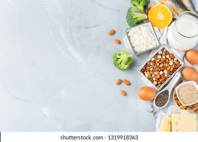 Balanced diet nutrition, healthy eating concept. Assortment of food sources rich in calcium, beans, dairy products, sardines, broccoli, chia seeds, almonds on a kitchen table. Copy space background