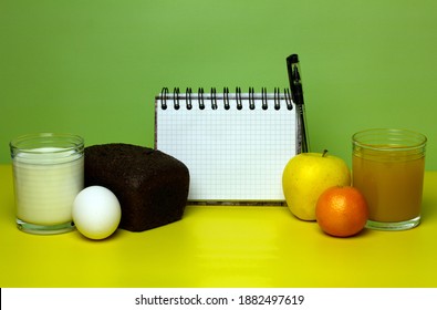 Balanced Nutrition Concept For Bland Diet. Milk, Bread, Eggs, Juice, Fruits On Yellow And Green Background. Weight Loss Planning Notebook. Copy Space.