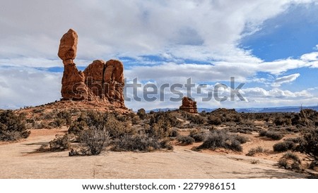 Balanced rock at Arches National Park in February with some blue sky fading to a snow storm.