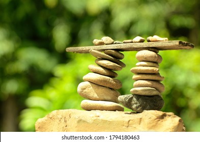 Close-up​ balanced small rock with green blurred background​
