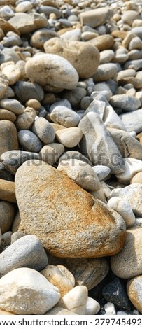 A balanced stack of three smooth river pebbles on a stony background, conveying mindfulness, inner peace, and perfect work-life balance