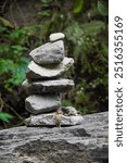 Balanced Stone Cairn in a Serene Forest. This simple yet profound composition serves as a reminder of the interconnectedness of all.