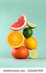 Balancing citrus fruits on the table. Pyramid of citrus fruits: grapefruit, lime, orange, lemon on a blue background. Copy Space.