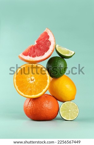 Balancing citrus fruits on the table. Pyramid of citrus fruits: grapefruit, lime, orange, lemon on a blue background. Copy Space.