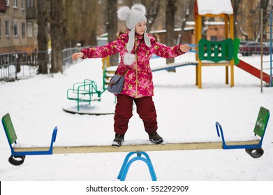 balancing girl stand on a teeter-totter
