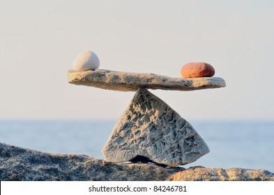 Balancing of pebbles on the top of boulder