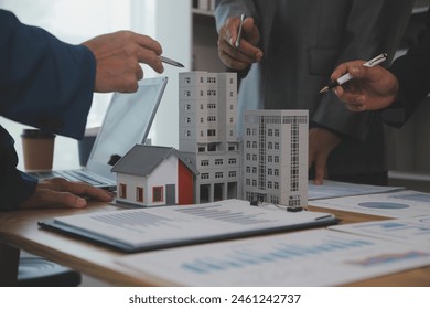 balancing the property sector The real estate agent is explaining the house style to see the house design and the purchase agreement.Wooden house at modern office - Powered by Shutterstock