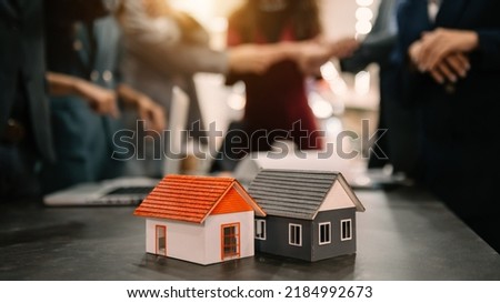 balancing the property sector The real estate agent is explaining the house style to see the house design and the purchase agreement.Wooden house at office 