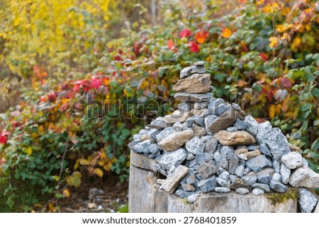 Balancing rock cairn representing stability and harmony with autumn leaves background