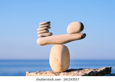 Balancing of white pebbles on the top of stone - Shutterstock ID 241193557