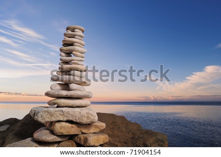 Balancing of white pebbles as tower on the sea coast