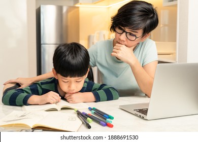 Balancing Work From Home With Kids During Covid-19 Pandemic Lockdown Concept. A Smart Looking Asian Mother Teaching Her Little Boy Reading. Homeschool, Manageable, Positive, Home-schooling Mom.