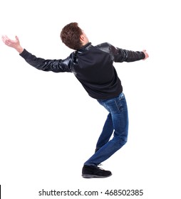 Balancing Young Man.  Or Dodge The Falling Man. Rear View People Collection.  Backside View Of Person.  Isolated Over White Background. Curly Guy In A Black Leather Jacket Falls On His Back.